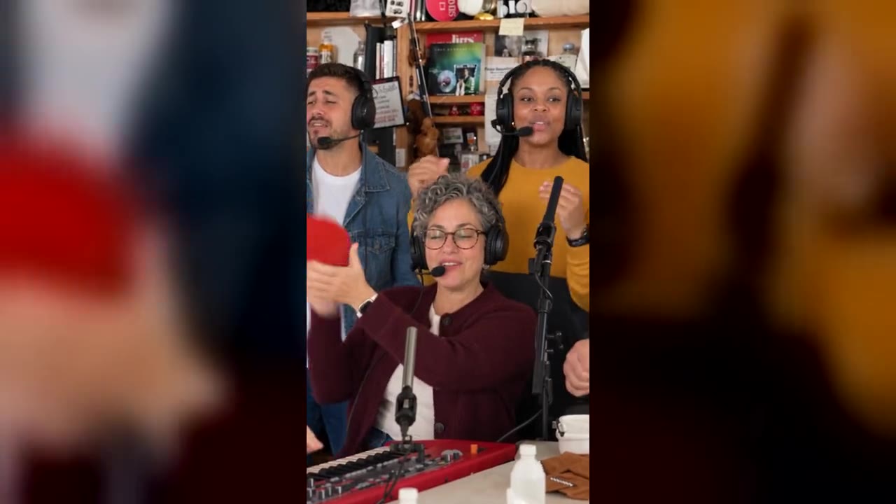 Outstanding Tiny Desk AI video: three singers in headphones behind a desk with a red keyboard